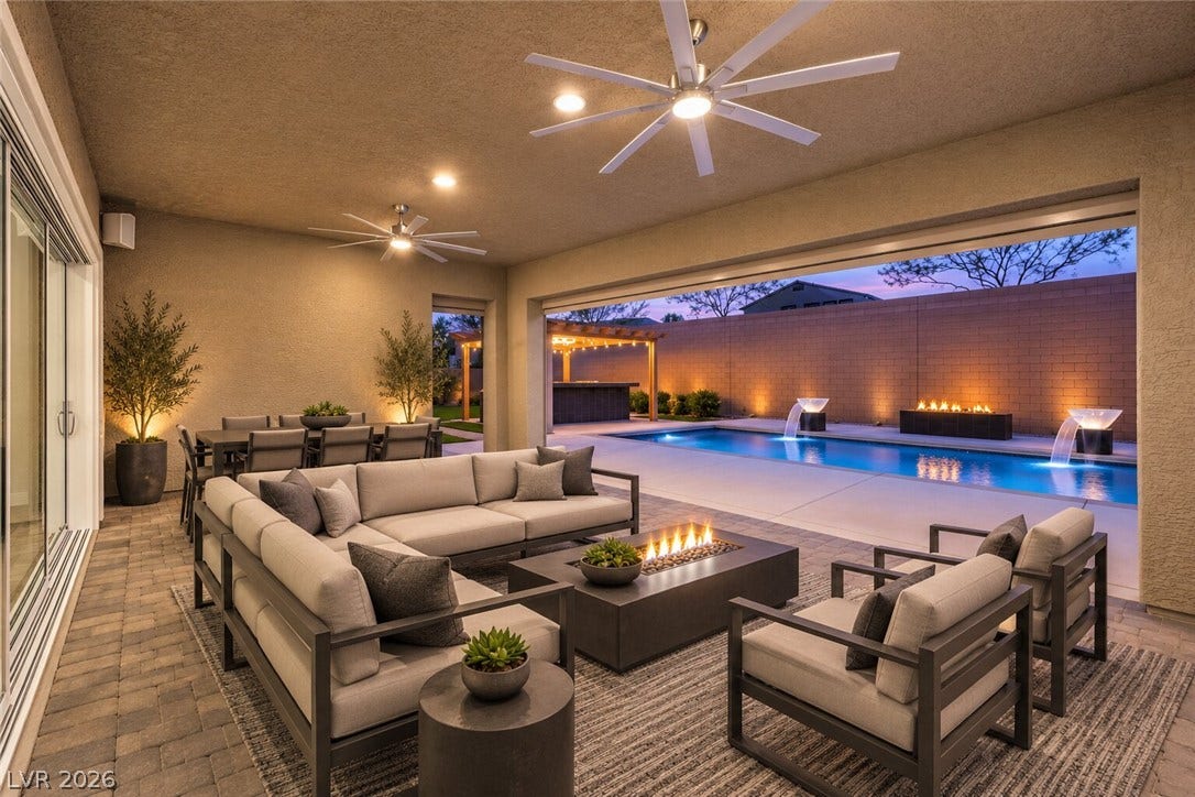 5455 Grambley Street, Las Vegas, NV 89149 Virtually staged- Large beautiful, covered patio with ceiling fans and speaker and recessed lights. Amazing pool with lighted water bowl and custom outdoor cooks' kitchen. remote patio screens.