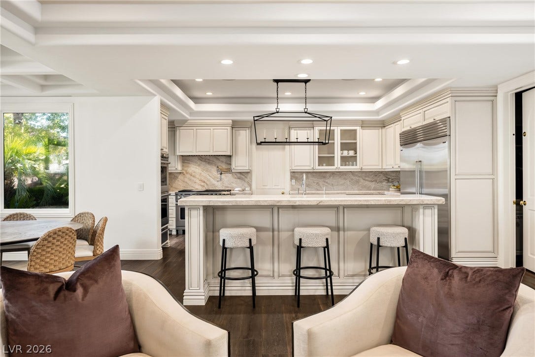 9817 Mountain Grove Court, Las Vegas, NV 89134 An open kitchen showcases rich hardwood floors, intricate tray ceilings, and a central island.
