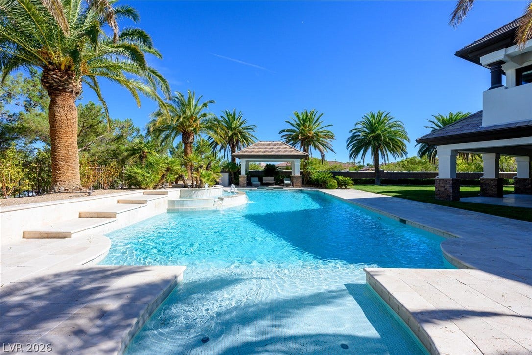 9817 Mountain Grove Court, Las Vegas, NV 89134 Lush palm trees and stone pavers surround a sparkling pool with an integrated spa.