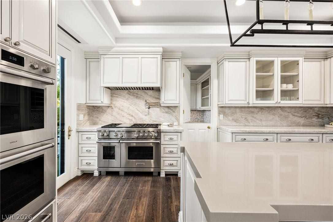 9817 Mountain Grove Court, Las Vegas, NV 89134 Gleaming stone countertops and custom cabinetry define this thoughtfully designed culinary workspace.