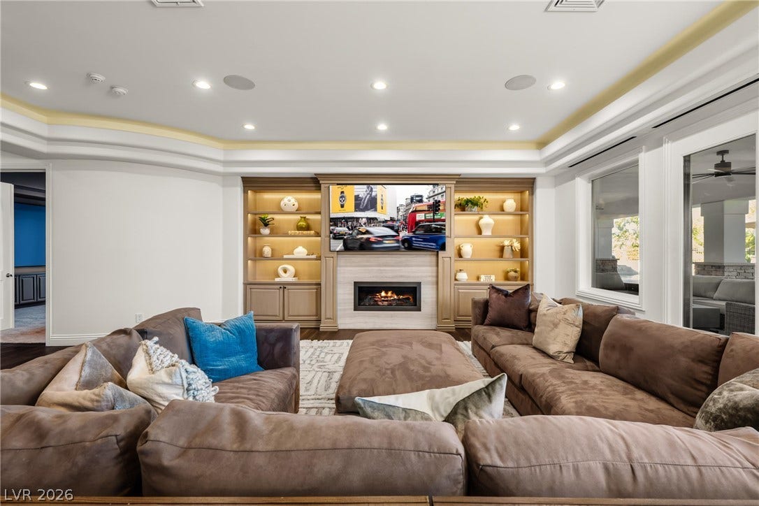 9817 Mountain Grove Court, Las Vegas, NV 89134 A customized media wall anchors this space with illuminated built-in shelving and a linear fireplace.