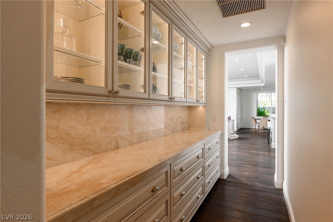 9817 Mountain Grove Court, Las Vegas, NV 89134 Custom butler pantry cabinetry coordinates beautifully with rich hardwood flooring flowing into the distance.