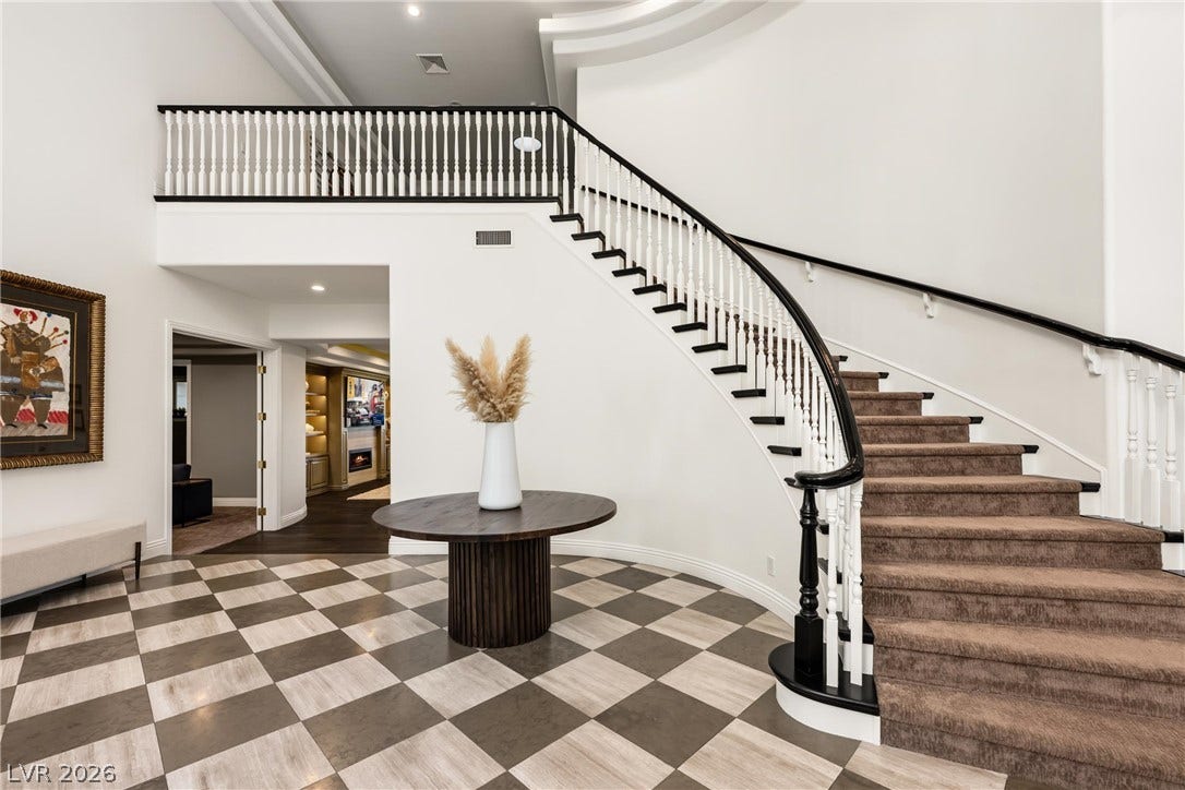 9817 Mountain Grove Court, Las Vegas, NV 89134 An elegant curved staircase anchors this grand entryway featuring patterned flooring and high ceilings.
