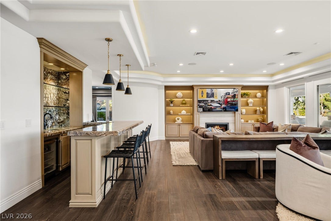 9817 Mountain Grove Court, Las Vegas, NV 89134 Rich hardwood floors complement the custom built-ins and stone-topped wet bar in this great room.
