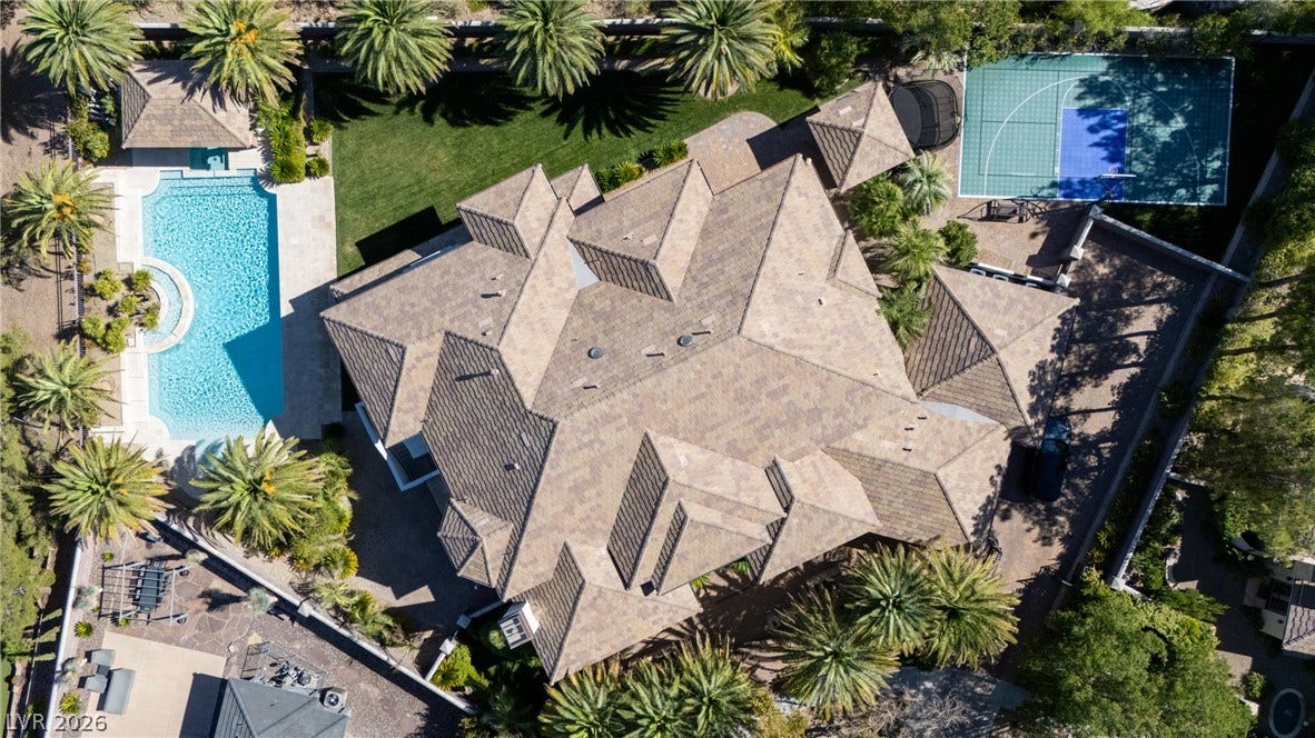 9817 Mountain Grove Court, Las Vegas, NV 89134 An aerial perspective reveals the multi-gabled tile roof alongside a private swimming pool and sports court.