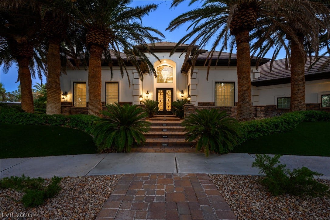 9817 Mountain Grove Court, Las Vegas, NV 89134 Towering palm trees frame a grand tiled entrance path leading to double front doors.