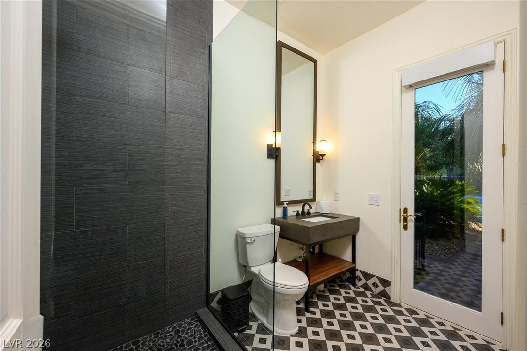 9817 Mountain Grove Court, Las Vegas, NV 89134 A glass-enclosed shower highlights this modern bathroom with custom tile floors and direct patio access.