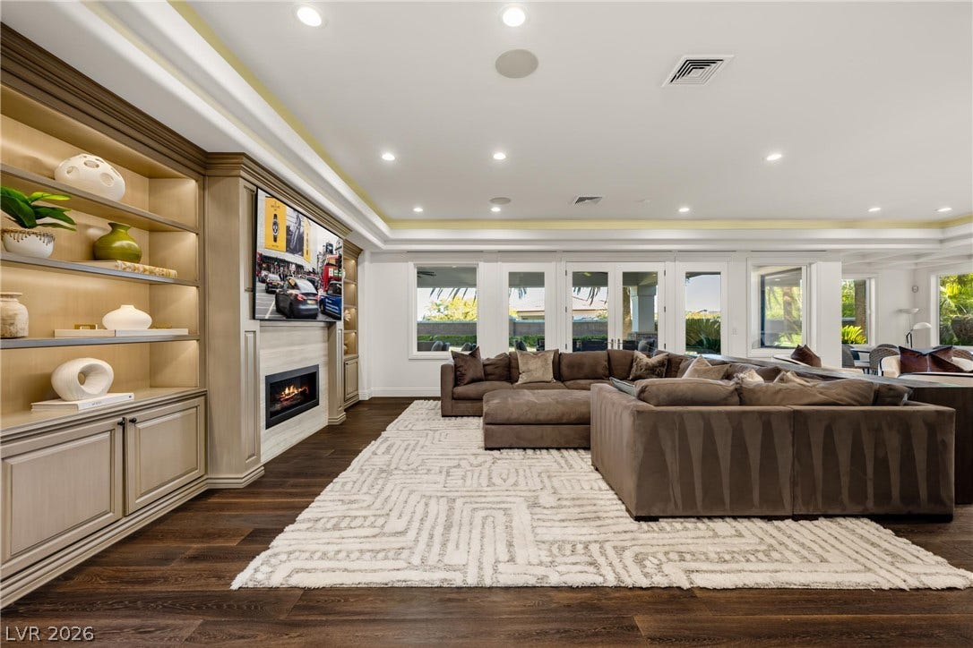 9817 Mountain Grove Court, Las Vegas, NV 89134 Rich hardwood floors and extensive custom built-ins flank a modern inset fireplace.