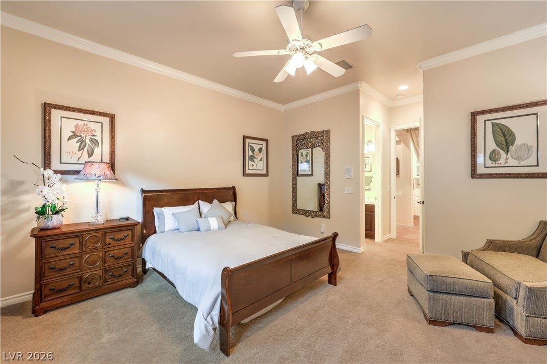 24 CROSS RIDGE Street, Las Vegas, NV 89135 Plush carpeting and elegant crown molding elevate this serene bedroom suite.