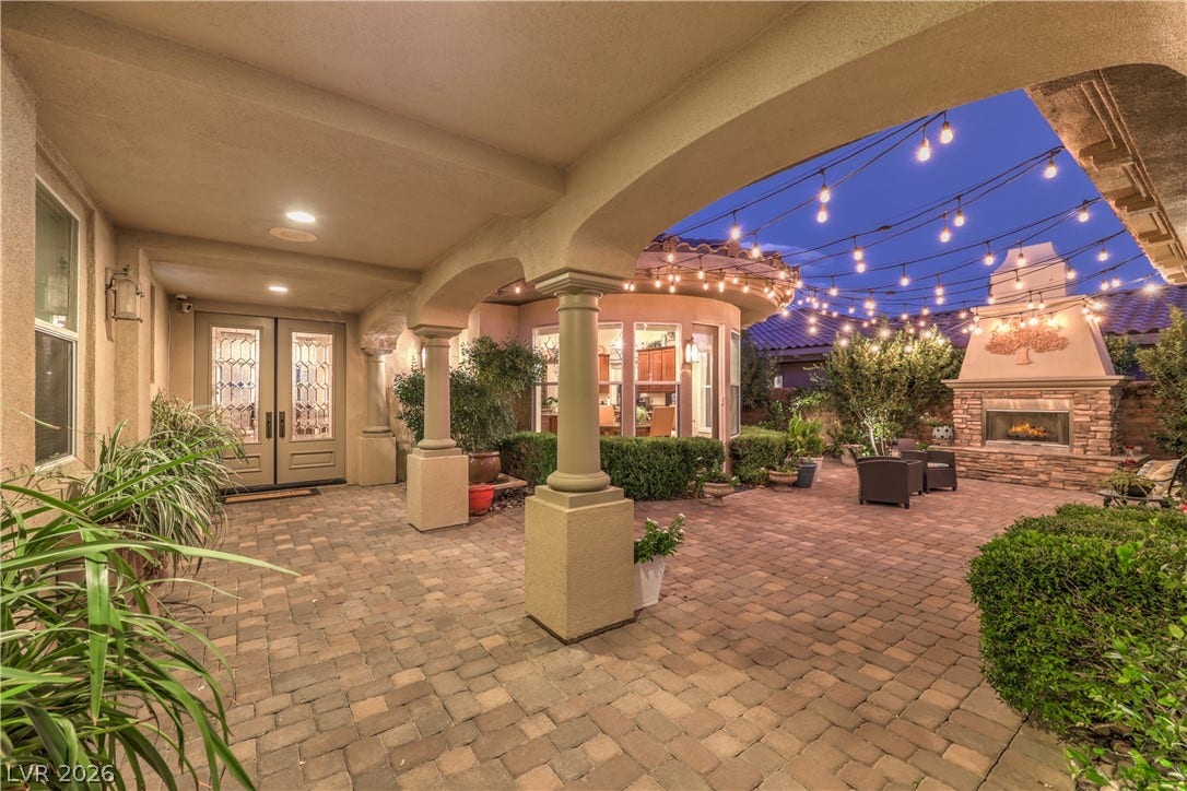 24 CROSS RIDGE Street, Las Vegas, NV 89135 A spacious covered patio leads directly to an inviting paver courtyard with an outdoor fireplace.