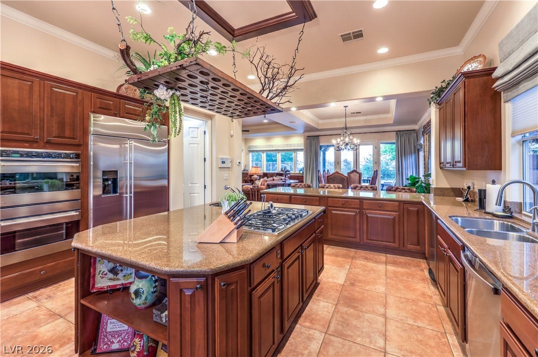 24 CROSS RIDGE Street, Las Vegas, NV 89135 Rich wood cabinetry paired with granite countertops anchors this spacious, open culinary space.