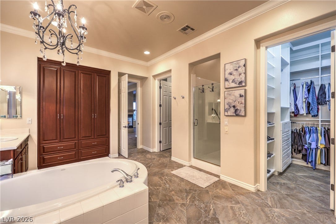 24 CROSS RIDGE Street, Las Vegas, NV 89135 Rich wood built-ins and tiled flooring complement this main bathroom retreat with adjacent walk-in closet.