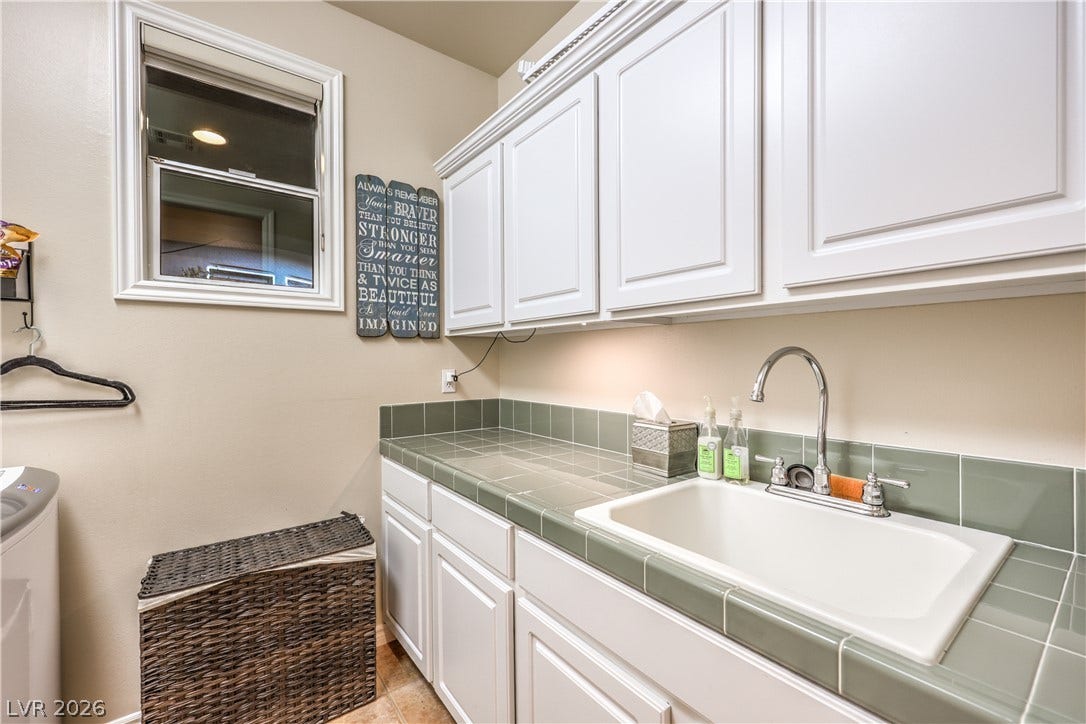 24 CROSS RIDGE Street, Las Vegas, NV 89135 White cabinetry paired with tiled countertops creates a highly functional utility space.