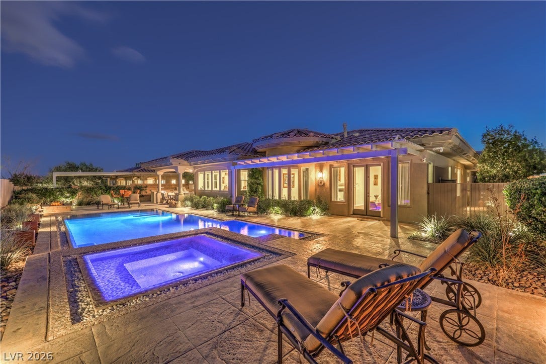 24 CROSS RIDGE Street, Las Vegas, NV 89135 An inviting backyard oasis features a gleaming pool and spa surrounded by textured stone patio decking.