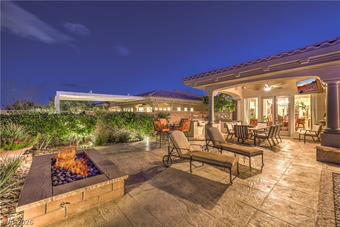 24 CROSS RIDGE Street, Las Vegas, NV 89135 An inviting stone-paved terrace features a built-in fire pit under twilight skies.