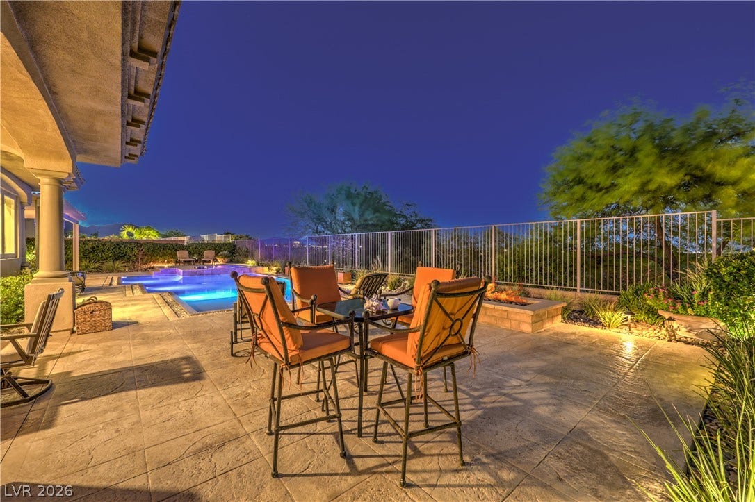 24 CROSS RIDGE Street, Las Vegas, NV 89135 A spacious stone patio opens to an inviting swimming pool under the evening sky.