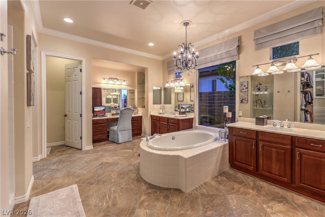 24 CROSS RIDGE Street, Las Vegas, NV 89135 An elegant soaking tub centers this grand bathroom featuring warm wood vanities and tile flooring.