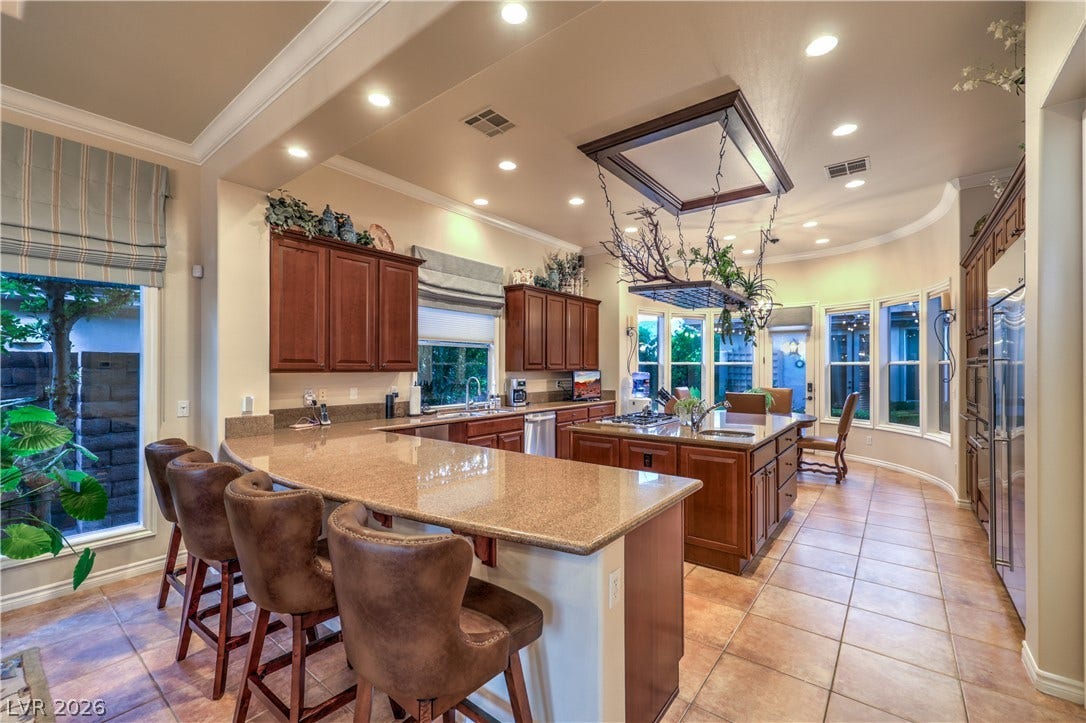24 CROSS RIDGE Street, Las Vegas, NV 89135 Polished granite countertops and classic wood cabinetry enrich this expansive culinary space.