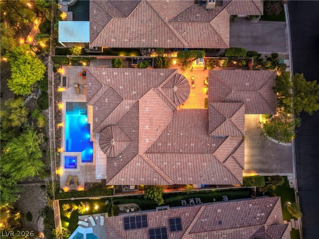 24 CROSS RIDGE Street, Las Vegas, NV 89135 Aerial perspective reveals the sweeping tile rooflines, private swimming pool, and stone paved drive.