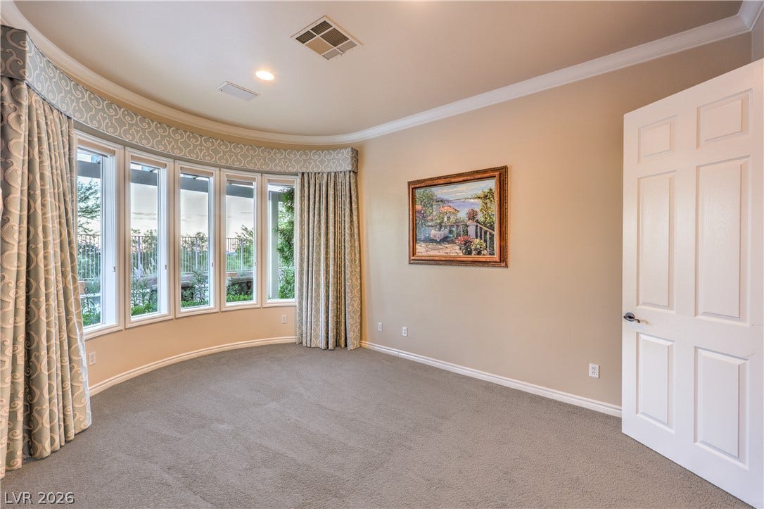 24 CROSS RIDGE Street, Las Vegas, NV 89135 A curved wall of windows illuminates this carpeted room bordered by elegant crown molding.