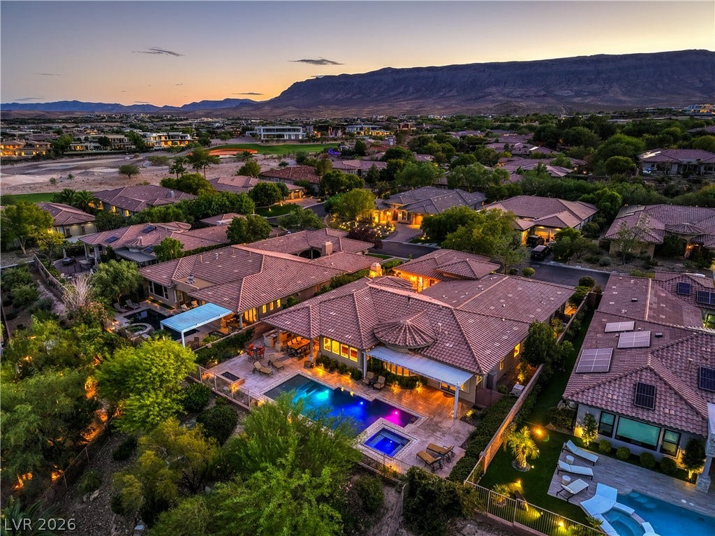 24 CROSS RIDGE Street, Las Vegas, NV 89135 An aerial perspective showcases a neighborhood of tiled roofs against a mountain backdrop.