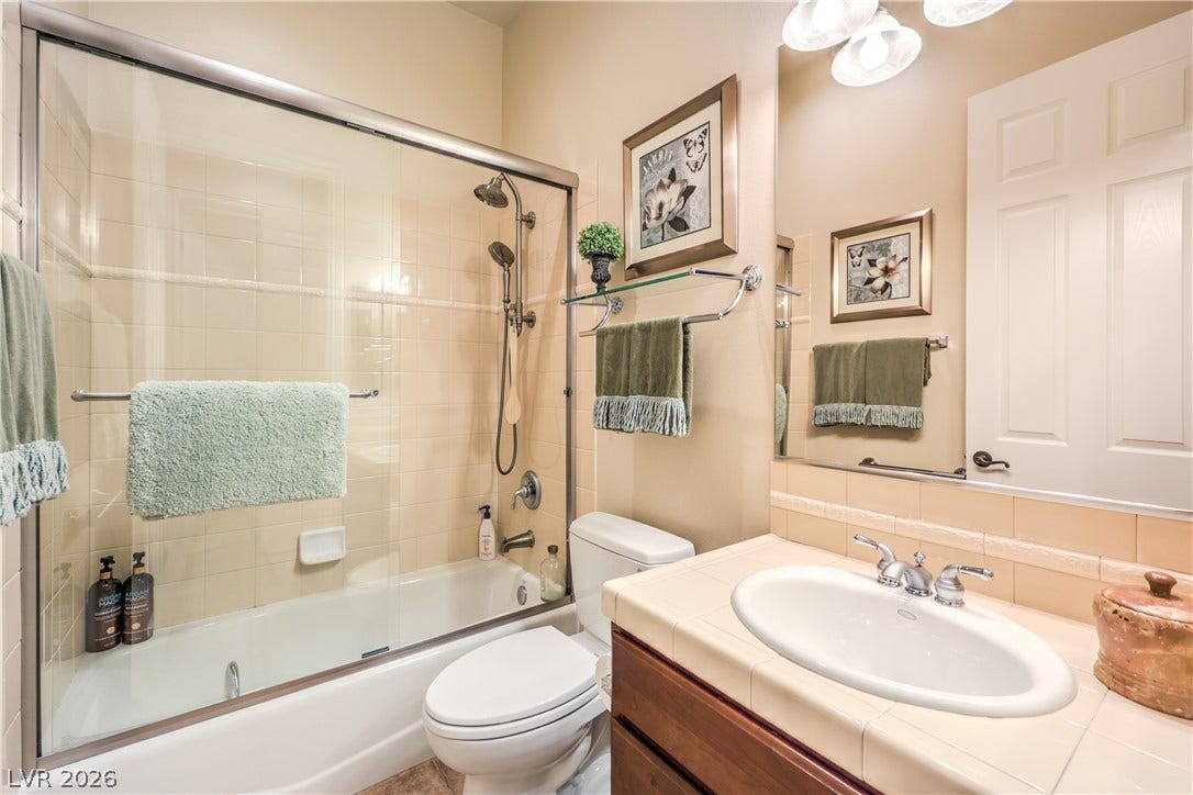 24 CROSS RIDGE Street, Las Vegas, NV 89135 A classic tiled vanity pairs perfectly with a glass-enclosed shower and tub combination.
