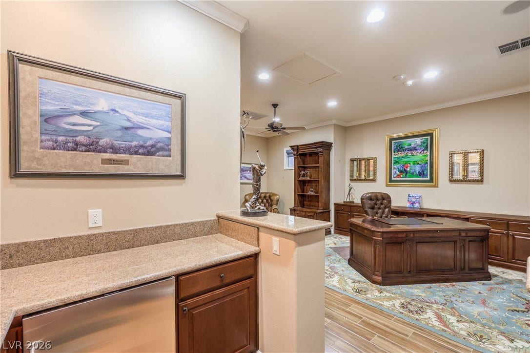 24 CROSS RIDGE Street, Las Vegas, NV 89135 Gleaming wood-look tile flooring and elegant crown molding elevate this spacious home workspace.