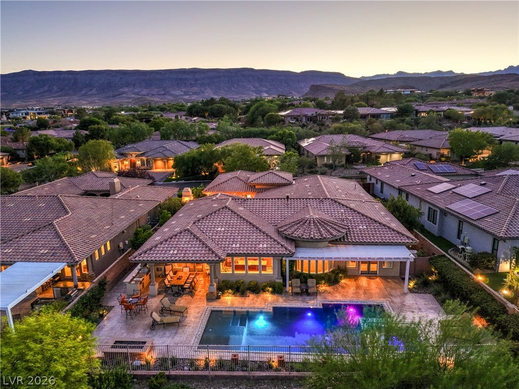 24 CROSS RIDGE Street, Las Vegas, NV 89135 A spacious stone patio and swimming pool set against a dramatic mountain backdrop.