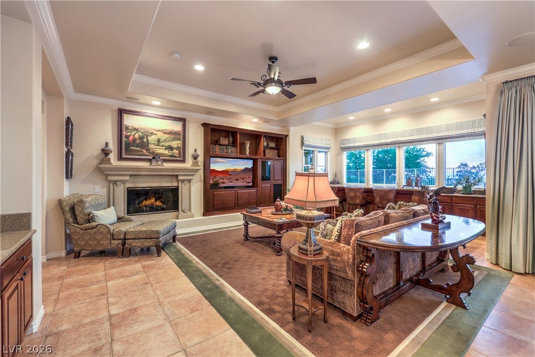 24 CROSS RIDGE Street, Las Vegas, NV 89135 An elegant fireplace anchors the spacious living area beneath a dramatic tray ceiling.