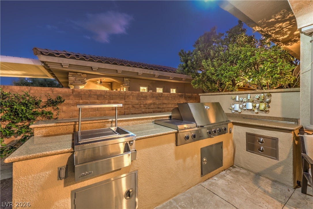 24 CROSS RIDGE Street, Las Vegas, NV 89135 An outdoor kitchen features durable stone counters and a built-in stainless steel grill.