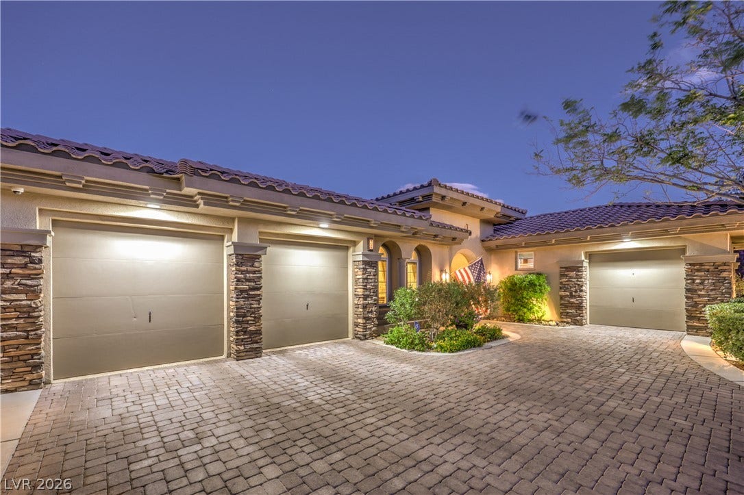 24 CROSS RIDGE Street, Las Vegas, NV 89135 An elegant paver driveway leads to a spacious multi-car garage beneath a tile roof.