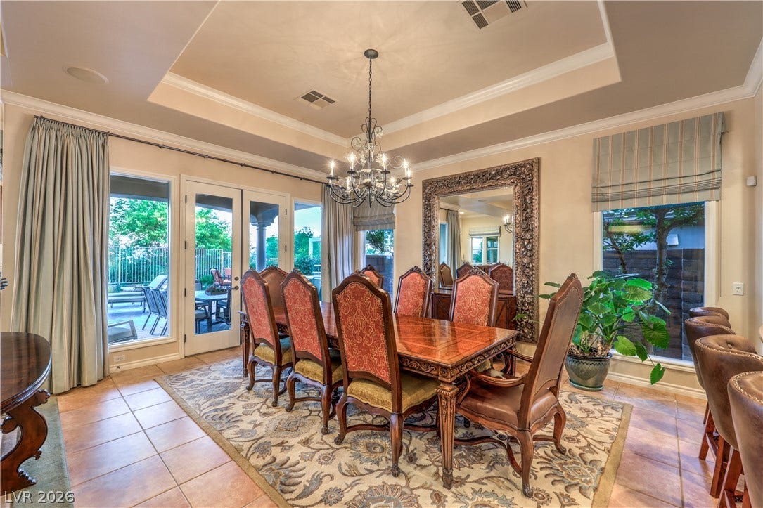 24 CROSS RIDGE Street, Las Vegas, NV 89135 An elegant dining space features a tiered tray ceiling, crown molding, and tiled flooring.