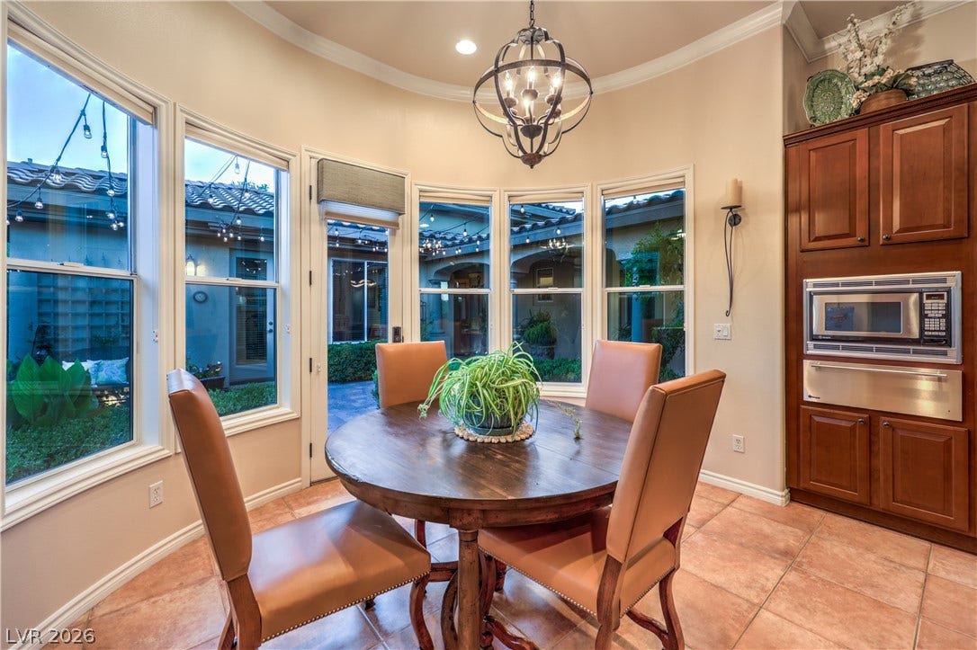 24 CROSS RIDGE Street, Las Vegas, NV 89135 A curved wall of windows illuminates this tiled dining area featuring built-in cabinetry and crown molding.
