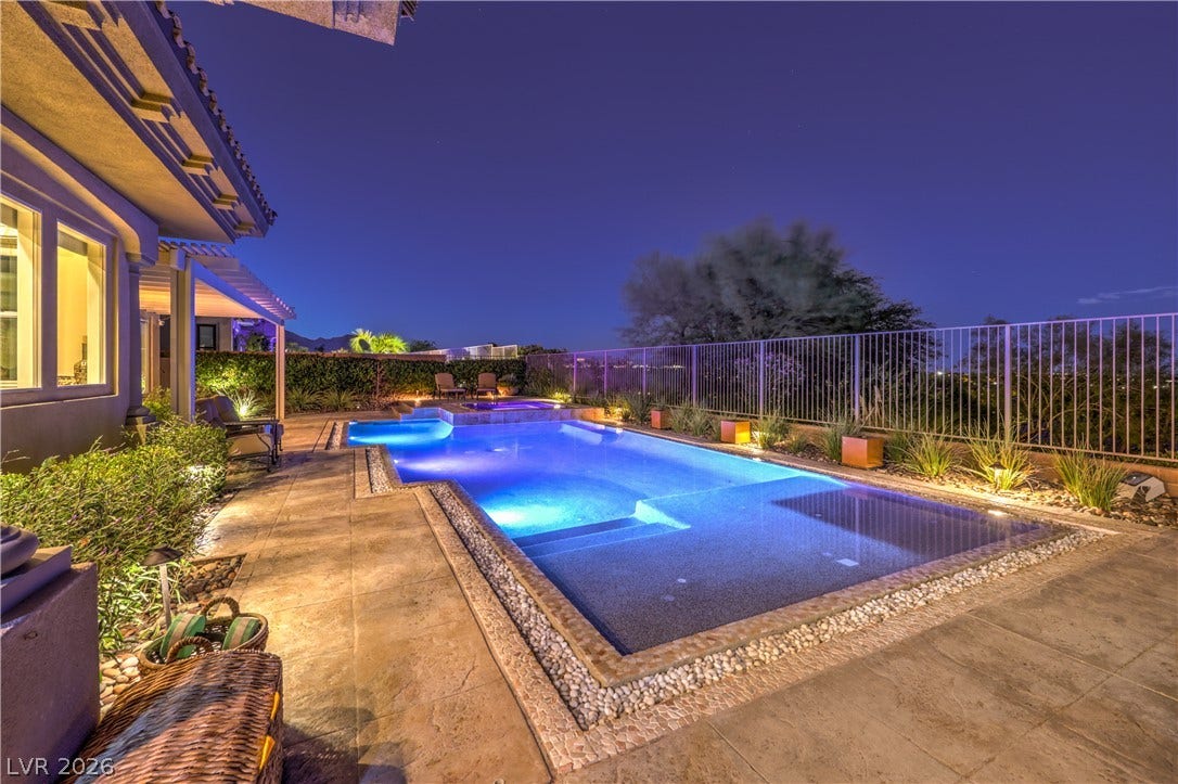 24 CROSS RIDGE Street, Las Vegas, NV 89135 An inviting backyard oasis showcases a pristine swimming pool beneath a twilight sky.
