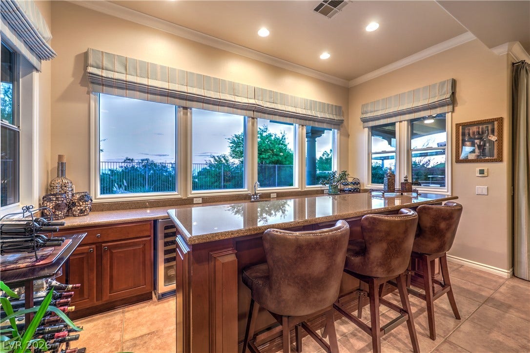 24 CROSS RIDGE Street, Las Vegas, NV 89135 Polished tile flooring and granite-topped counters anchor this home bar space bordered by windows.