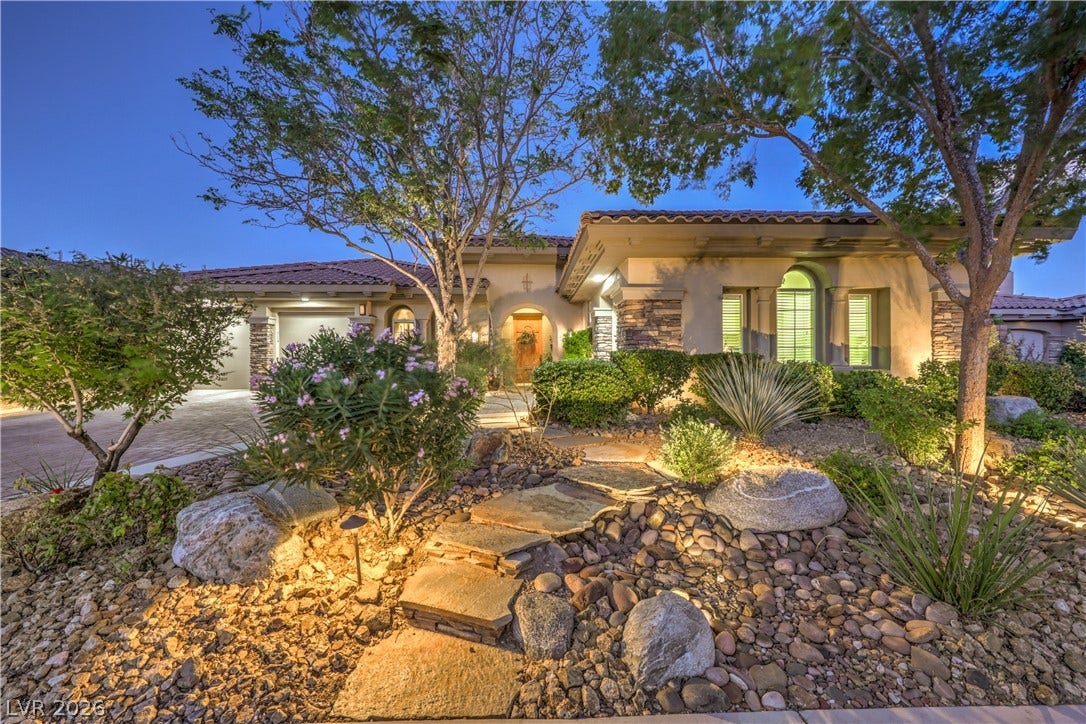 24 CROSS RIDGE Street, Las Vegas, NV 89135 Lush desert landscaping and a flagstone path create an inviting approach to this elegant home.