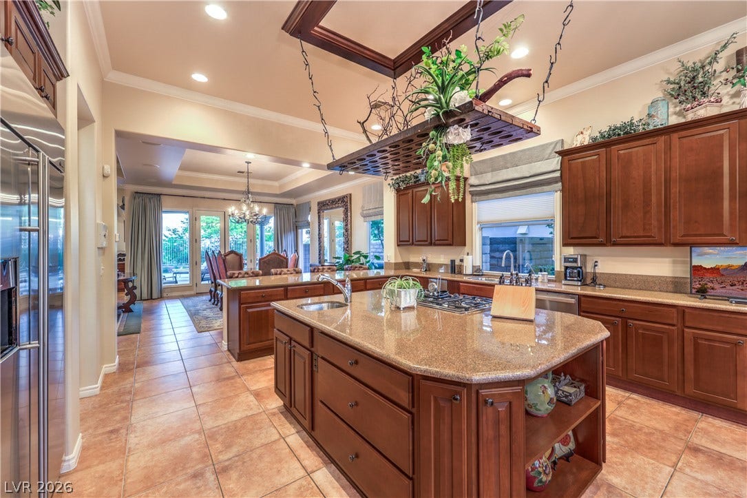 24 CROSS RIDGE Street, Las Vegas, NV 89135 Gleaming stone countertops and classic wood cabinetry define this expansive, open kitchen space.