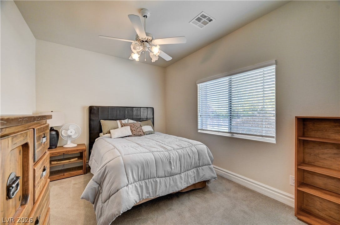 2201 Double Tree Avenue, Henderson, NV 89052 Plentiful natural light streams through a wide window into this cozy carpeted bedroom.