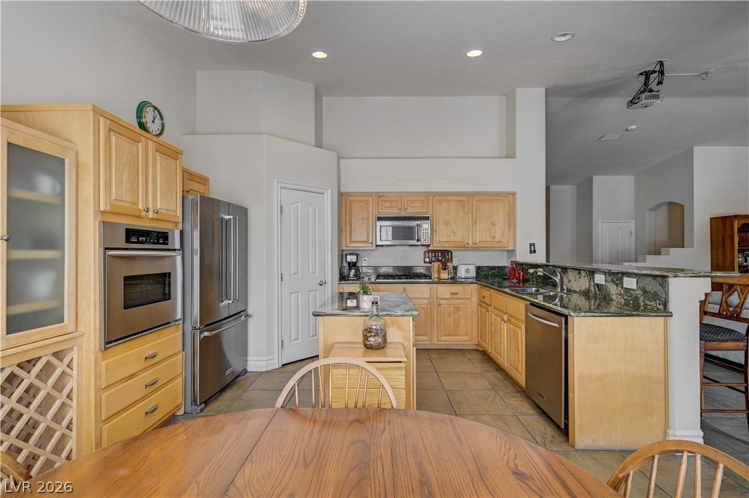 2201 Double Tree Avenue, Henderson, NV 89052 Gleaming tile floors and natural wood cabinetry anchor this spacious culinary space.