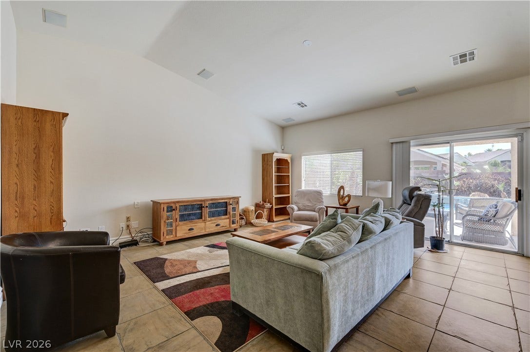 2201 Double Tree Avenue, Henderson, NV 89052 Vaulted ceilings and tile flooring enhance this open-concept living area leading outdoors.