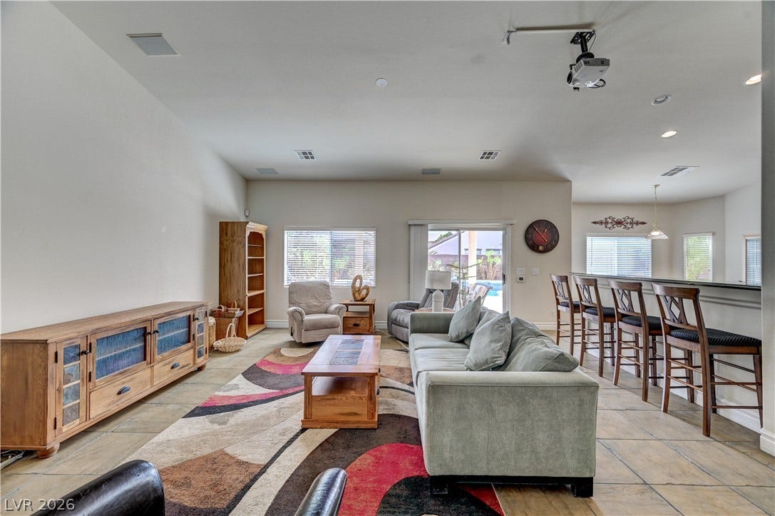 2201 Double Tree Avenue, Henderson, NV 89052 An open floorplan living space showcases tile flooring and glass sliding doors to the pool area.