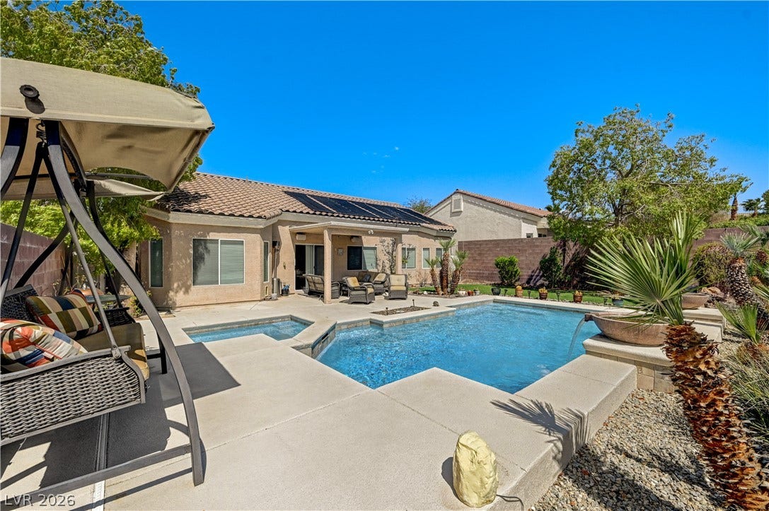 2201 Double Tree Avenue, Henderson, NV 89052 An inviting backyard oasis features a pristine swimming pool and spa surrounded by concrete decking.