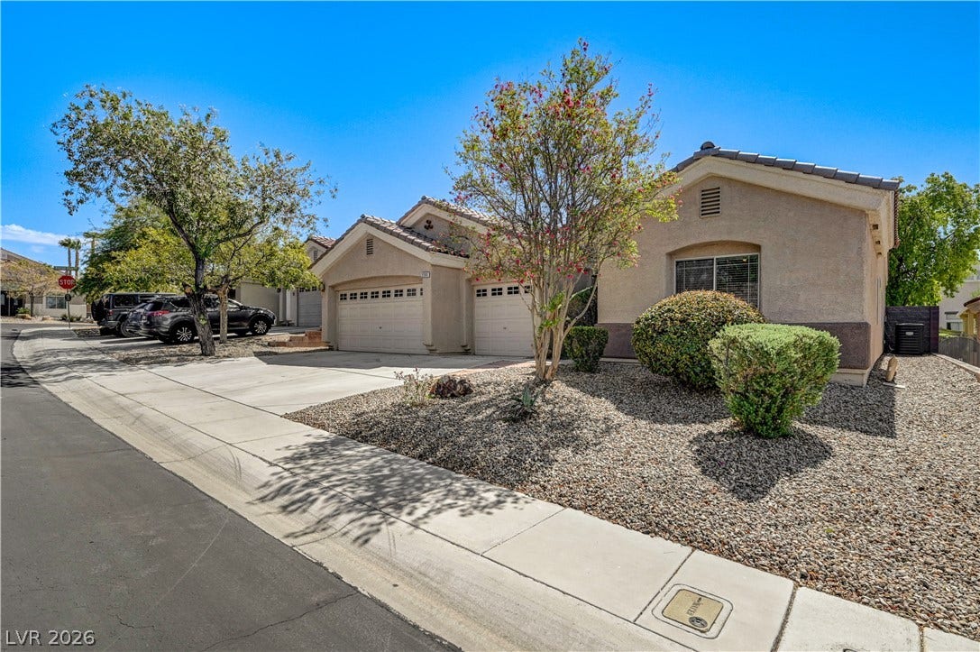 2201 Double Tree Avenue, Henderson, NV 89052 Manicured desert landscaping frames the stucco exterior and attached garage of this single-story home.