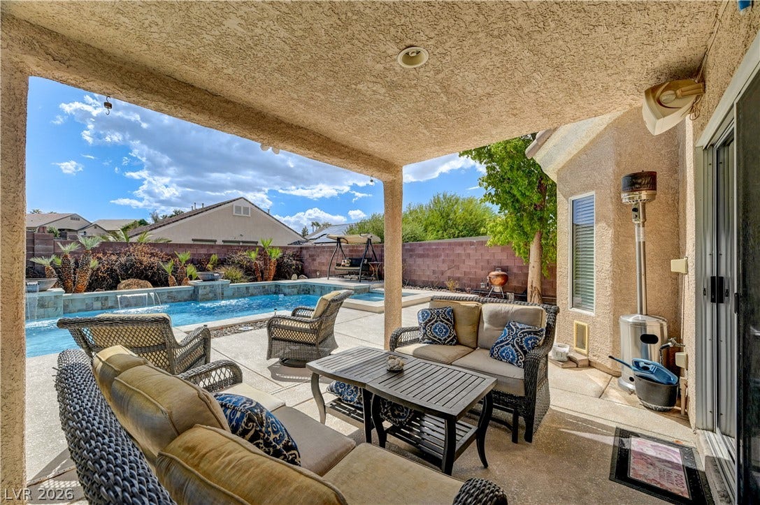 2201 Double Tree Avenue, Henderson, NV 89052 A sheltered concrete patio overlooks the private backyard swimming pool under a bright desert sky.