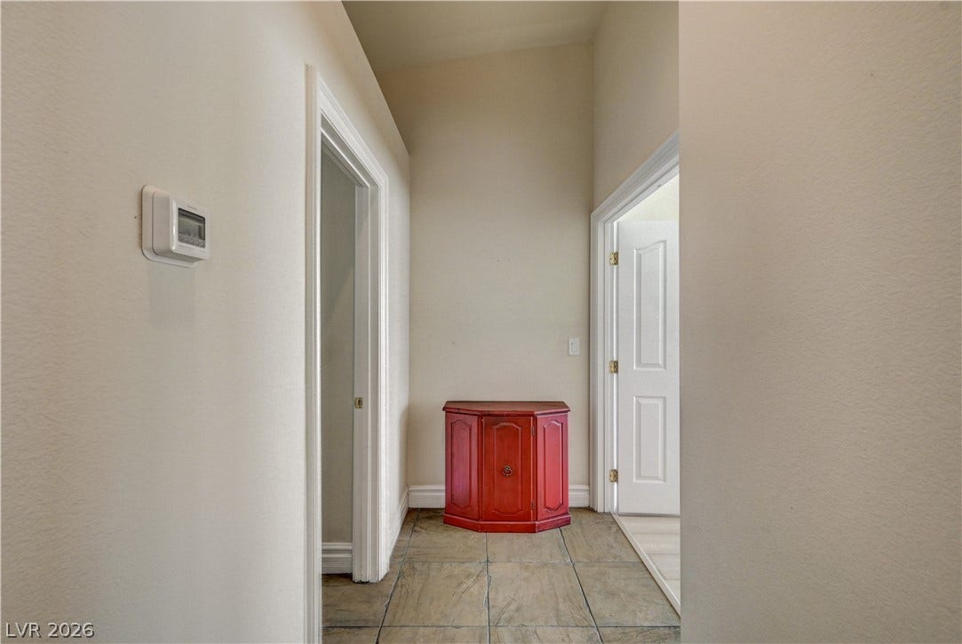 2201 Double Tree Avenue, Henderson, NV 89052 A high-ceilinged hallway features durable tile flooring and crisp white trimwork.