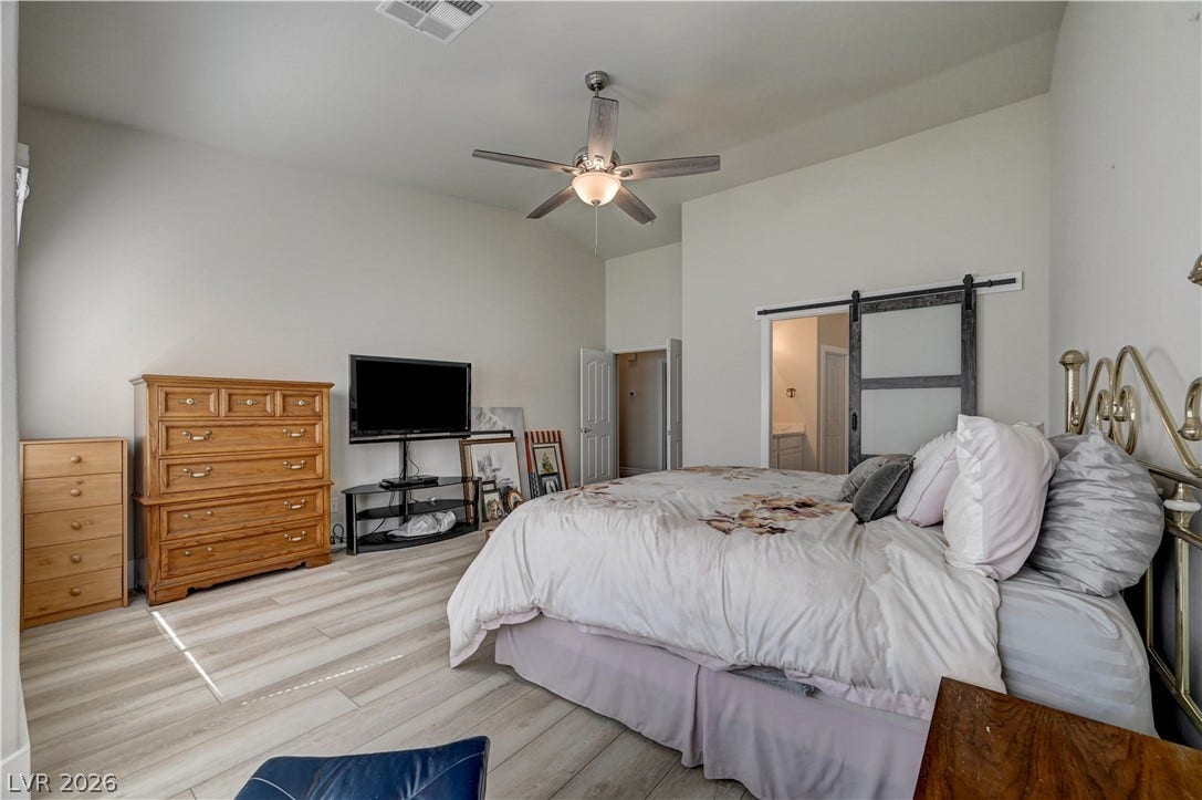 2201 Double Tree Avenue, Henderson, NV 89052 High ceilings and light wood floors elevate this spacious bedroom retreat.
