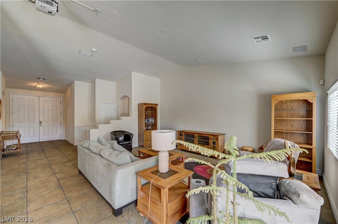 2201 Double Tree Avenue, Henderson, NV 89052 An open floorplan living room highlights neutral walls and neutral tile flooring.