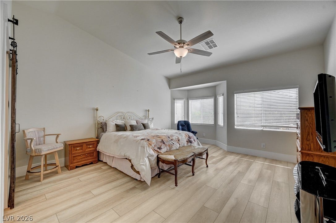 2201 Double Tree Avenue, Henderson, NV 89052 High ceilings and clean wood-look flooring establish a serene, airy feel in this bedroom retreat.