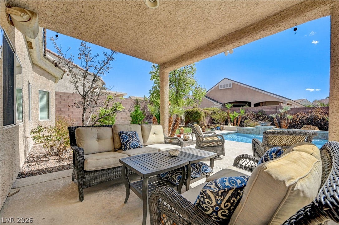 2201 Double Tree Avenue, Henderson, NV 89052 Shaded concrete patio opens to a private backyard swimming pool under sunny skies.