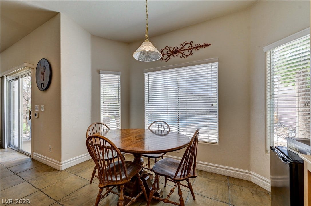 2201 Double Tree Avenue, Henderson, NV 89052 Sunlight streams through multiple windows highlighting the textured tile flooring and tall baseboards.